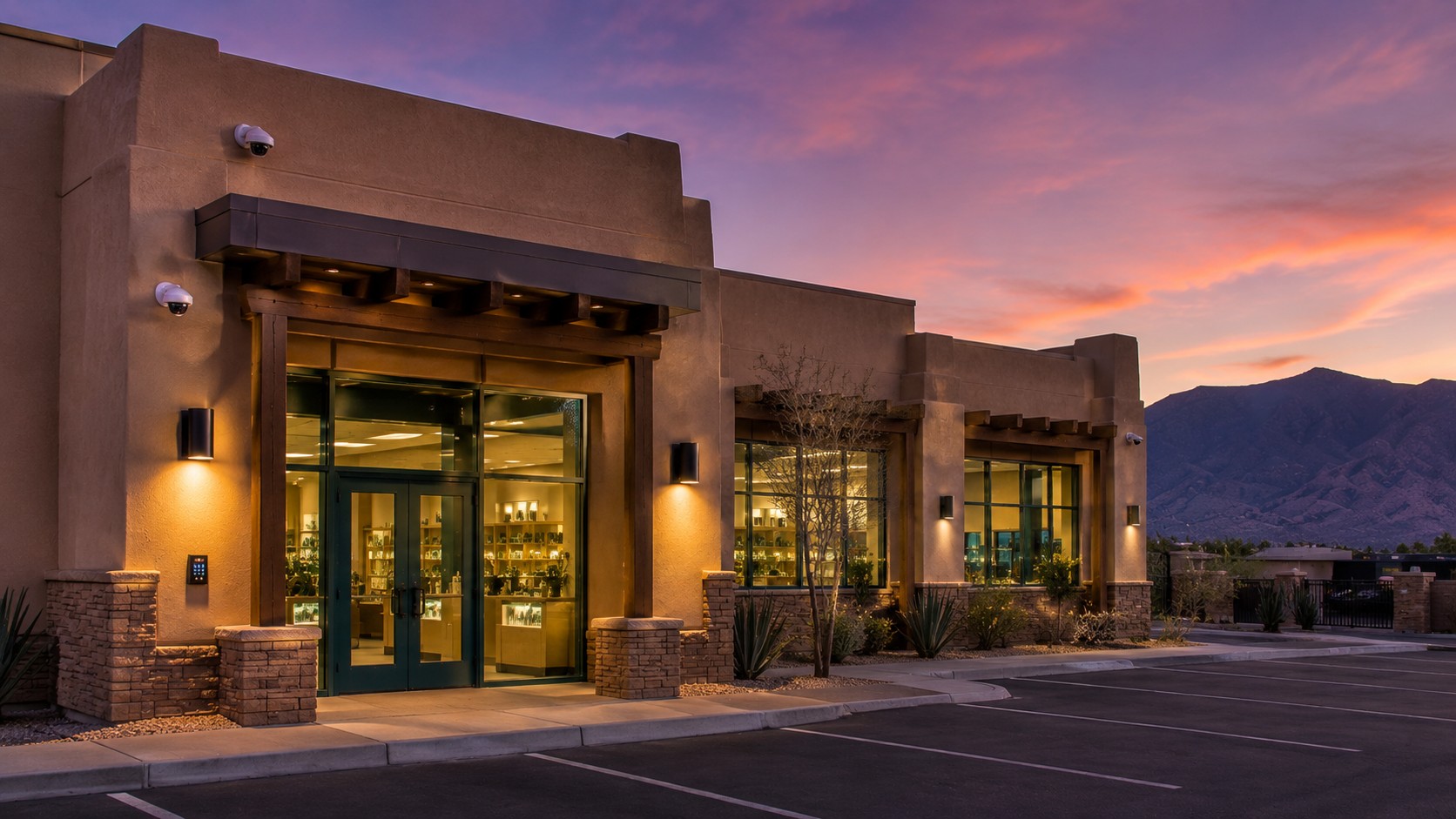 Exterior of a New Mexico cannabis dispensary at dusk with commercial security cameras and keypad access at the front entry.
