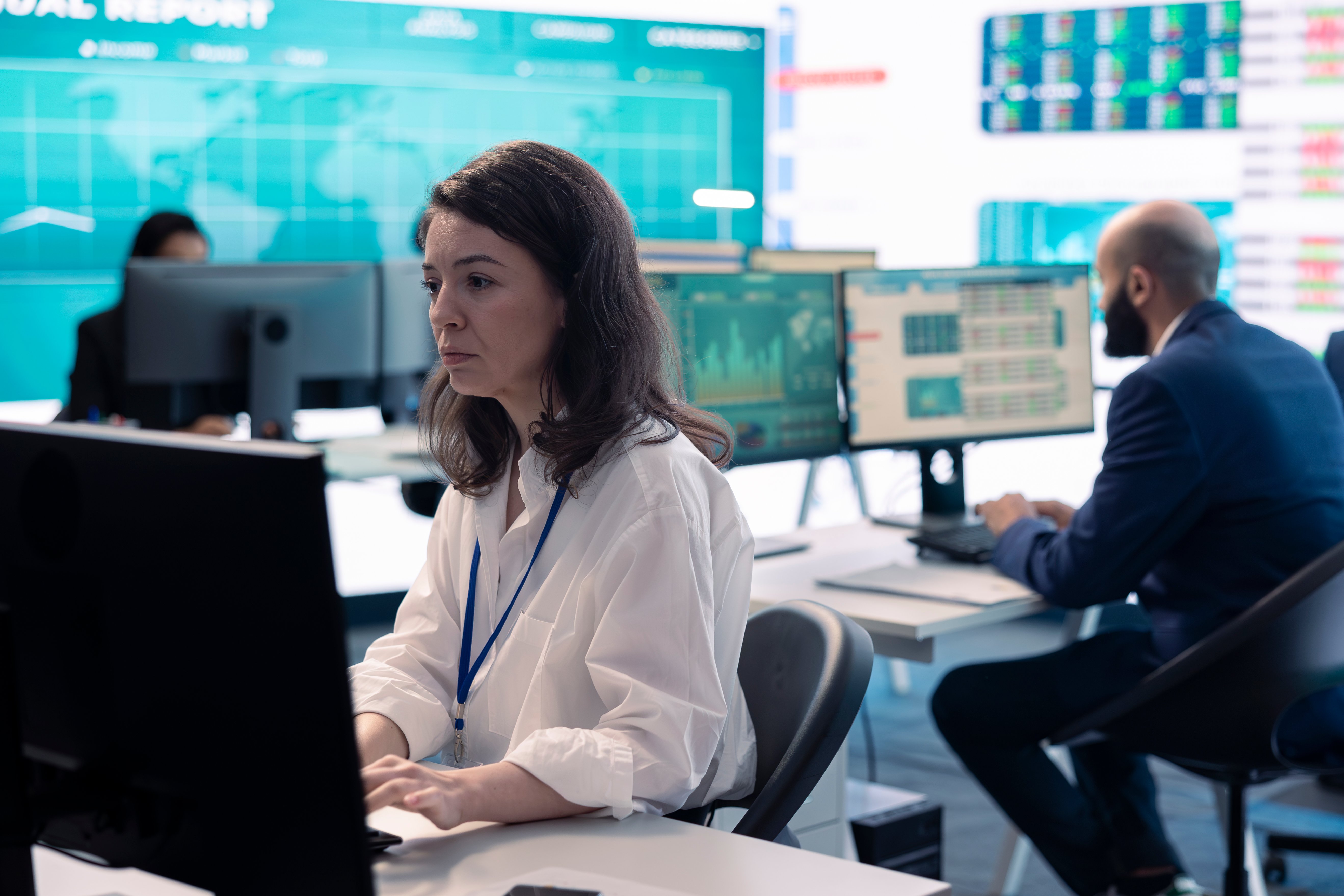 IT operations team managing multiple systems on screens in office